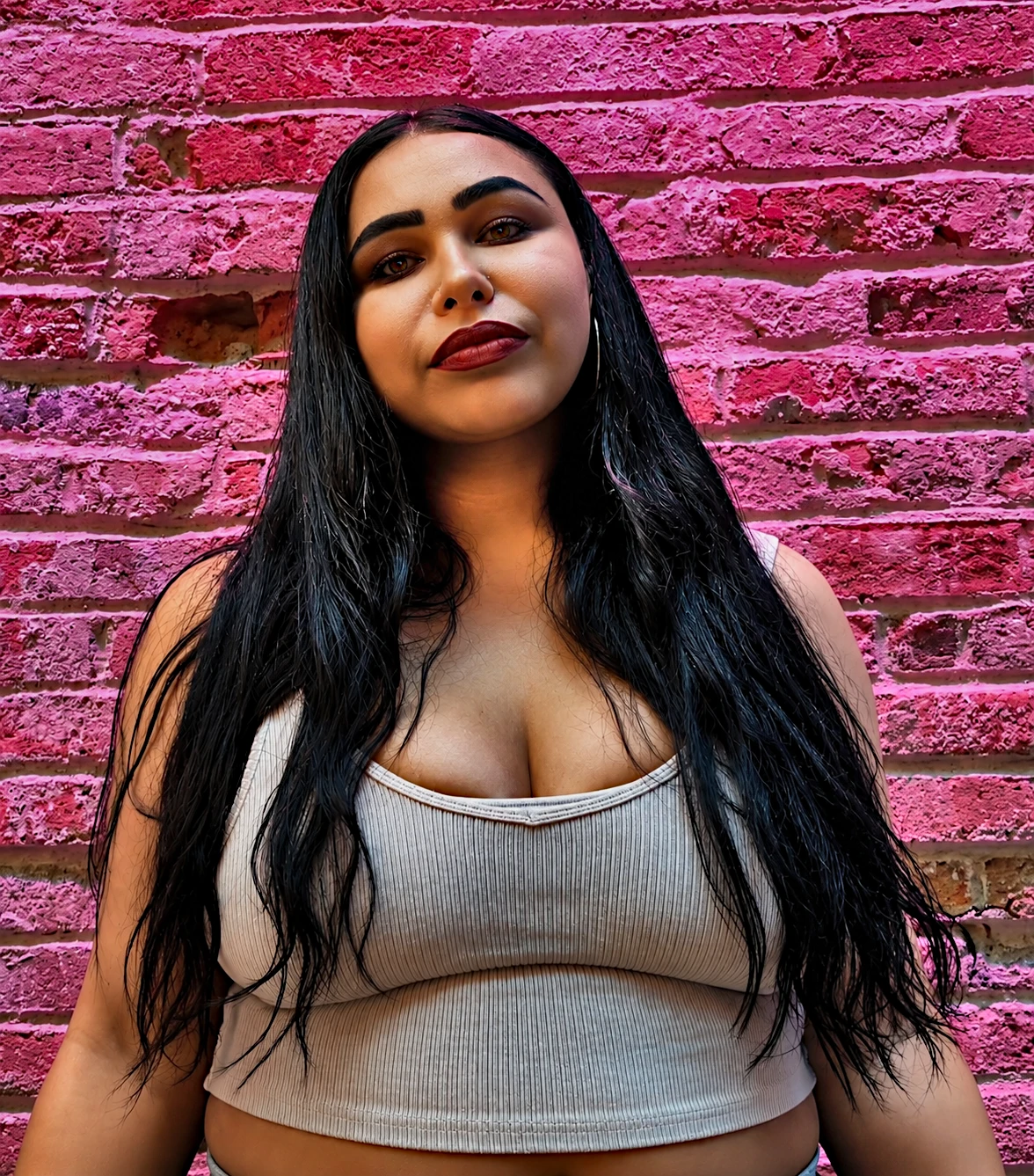 TS Day posing in front of a vivid pink brick wall